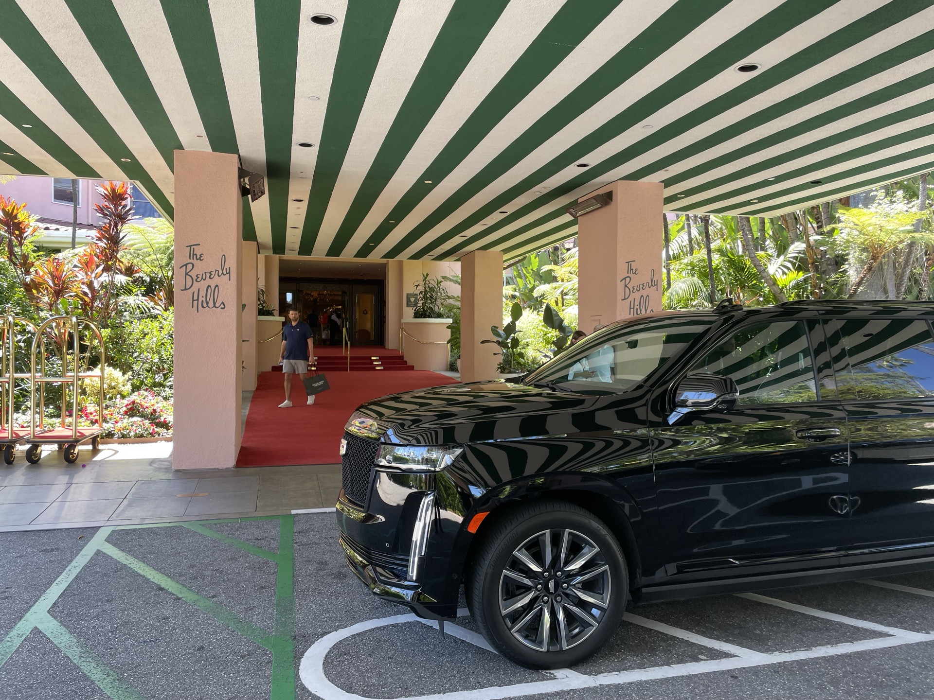 Continental Cadillac Escalade waiting under a Beverly Hills hotel porte-cochère — multi-day chauffeur service, Los Angeles